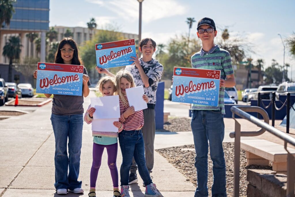 Homeschool students holding Welcome to Homeschool Day at the Capitol signs